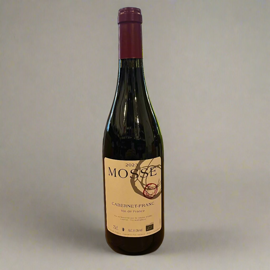 Bottle of Mosse Cabernet Franc wine on a wooden table with a store interior in the background.