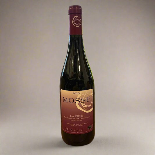 Red wine bottle labeled 'MOSSE' on a wooden table with a store interior background.
