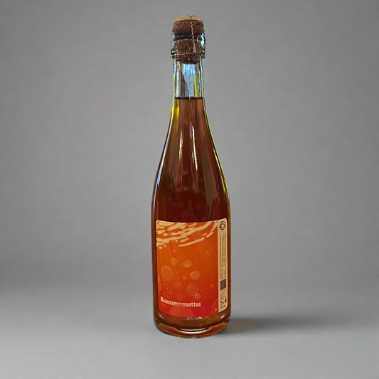 Bottle of rsparkling osé wine on a wooden table with a bar setting in the background